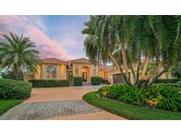 Elegant home featuring lush landscaping, a terracotta roof, and a circular driveway at 909 Macewen Dr, Osprey, FL 34229