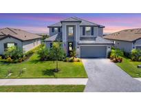 Two-story house with gray siding, tile roof, and a 2-car garage at 15530 Islandwalk Ave, Bradenton, FL 34211