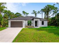 Newly built home with a modern design, two-car garage and landscaping at 14390 Maddock Ave, Port Charlotte, FL 33953