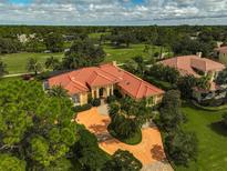 Luxury home with tile roof and circular driveway, aerial view at 909 Macewen Dr, Osprey, FL 34229