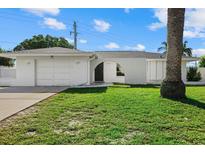 White single-story house with a garage and palm trees in the front yard at 1160 Morningside Pl, Sarasota, FL 34236