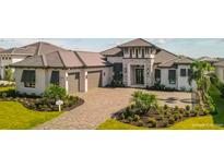 Beautiful single-Gathering home featuring a barrel tile roof, a paved driveway, and a meticulously landscaped front yard at 1107 Blue Shell Loop, Sarasota, FL 34240