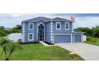 Two-story house with a two-car garage and landscaped lawn at 14312 Barbarossa Ln, Port Charlotte, FL 33981