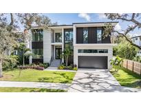 Modern two-story home with a two-car garage and landscaped yard at 214 S Renellie Dr, Tampa, FL 33609