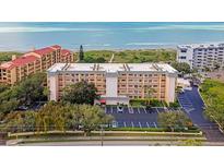 Oceanfront condo building with parking and lush landscaping at 8630 Midnight Pass Rd # 103A, Sarasota, FL 34242