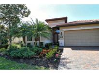 Mediterranean style home with a paver driveway and nicely landscaped yard at 1130 Cielo Ct, North Venice, FL 34275