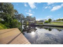 Scenic canal view from a private dock, reflecting the sky and surrounding trees at 4532 Shark Dr, Bradenton, FL 34208