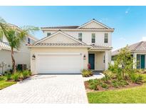 Two-story house with white siding, gray roof, and two-car garage at 2803 Butterfly Jasmine Trl, Sarasota, FL 34240