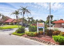 Sunrise Condominium entrance with lush landscaping and parking at 6384 Draw Ln # 38, Sarasota, FL 34238