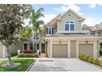 Tan two-story townhome with two-car garage, landscaping, and walkway at 7922 Tybee Ct, University Park, FL 34201