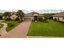 Luxury home with a large lawn and brick driveway at 4803 Cabreo Ct, Bradenton, FL 34211