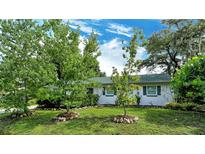Landscaped front yard with lush green grass and mature trees at 4724 Seville Dr, Sarasota, FL 34235