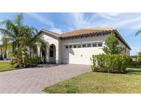 One-story home with a tile roof, white garage door, and landscaped yard at 1922 6Th St E, Palmetto, FL 34221