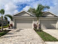 Two-car garage with paver driveway and landscaping at 4254 Golden Creek Ter, Parrish, FL 34219