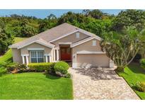 Single-story home with light beige walls, red door, and paver driveway at 5111 51St W Ln, Bradenton, FL 34210