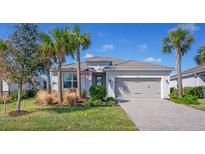 One-story house with gray garage door and palm trees at 14573 Ponce De Leon Trl, Port Charlotte, FL 33981