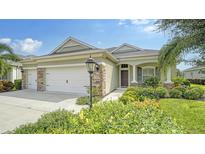 Charming home with a three-car garage, stone accents, and beautifully landscaped front yard at 16916 Rosedown Gln, Parrish, FL 34219