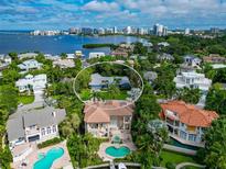 Stunning aerial view of property showcasing a home, lush landscaping and waterfront views in the background at 1389 Harbor Dr, Sarasota, FL 34239