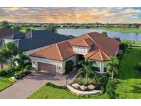 Luxury home with tile roof and landscaping near a lake at 15115 Montello Way, Lakewood Ranch, FL 34211