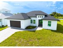 Modern home with dark brown garage door and paver driveway at 1094 Rotonda Cir, Rotonda West, FL 33947