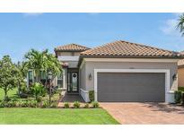 Single-story home with gray exterior, two-car garage, and landscaped yard at 4507 Terrazza Ct, Bradenton, FL 34211