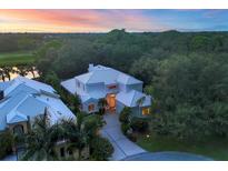 Stunning property showcasing a home with a white roof, lush landscaping, and a private driveway at 7620 Club Ln, Sarasota, FL 34238