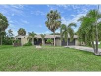 Single-story home with a large grassy yard and mature palm trees at 6106 45Th W St, Bradenton, FL 34210