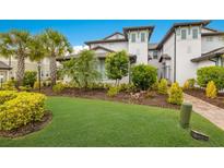 Two-story home with lush landscaping and brick driveway at 7390 Divot Loop, Lakewood Ranch, FL 34202