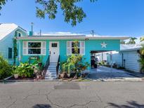 Charming bungalow style home with light teal exterior, white shutters, and lush landscaping at 3 Palm Ave, Bradenton, FL 34208