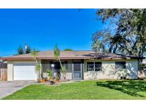 Ranch-style house with a white garage door and well-maintained lawn at 1208 Leeward Rd, Venice, FL 34293