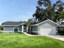 Newly constructed home with gray exterior, a two-car garage, and a well-manicured lawn at 5278 Sabrina Ter, North Port, FL 34286