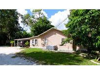 Tan house exterior with carport and landscaping at 1820 7Th E Ave, Bradenton, FL 34208