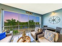 Relaxing lanai with wicker furniture, offering stunning sunset views over the water at 391 Aruba Cir # 302, Bradenton, FL 34209