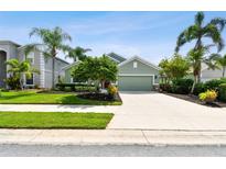 House exterior, green two-car garage, manicured lawn, palm trees at 5056 Lakehurst Ct, Palmetto, FL 34221