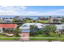 A beautiful two-story waterfront home features a metal roof, manicured lawn, and lush landscaping at 239 Fry Se Ter, Port Charlotte, FL 33952