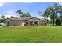 Single-story home with a well-manicured lawn at 11358 Lomita Wren Rd, Weeki Wachee, FL 34614