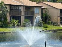 Condo building overlooks a lake with fountain and mature tropical landscaping with screened in balcony at 3810 75Th W St # 116, Bradenton, FL 34209