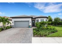 Modern two-car garage home with landscaped yard at 14480 Eagle Branch Dr, Nokomis, FL 34275