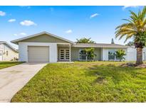 Newly renovated home with modern facade, attached garage, and lush lawn at 6403 1St W Ave, Bradenton, FL 34209