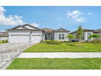 Two-story home with gray siding, two-car garage and lush landscaping at 9018 Sunray Cv, Parrish, FL 34219