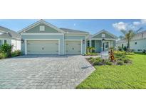 Two-car garage home with paver driveway and landscaping at 21281 Holmes Cir, Venice, FL 34293