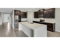 Modern kitchen boasting dark cabinetry, quartz countertops, and stainless steel appliances at 12354 Nantahala Run, Parrish, FL 34219