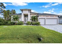 Modern two-story house with a two-car garage and manicured lawn at 14219 Wenzel Ave, Port Charlotte, FL 33981