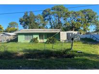 Small green house with damaged roof and overgrown yard at 108 Sago Ln, Nokomis, FL 34275