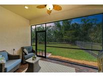Cozy screened lanai with comfortable seating, patterned rug, and peaceful backyard views at 7572 Viola Loop, Lakewood Ranch, FL 34202
