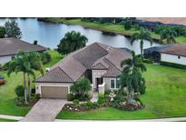 Single-Gathering home with tile roof, landscaping, and a view of a lake at 12663 Fontana Loop, Bradenton, FL 34211