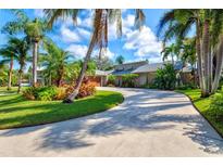 House exterior with circular driveway and tropical landscaping at 900 26Th W Ave, Palmetto, FL 34221