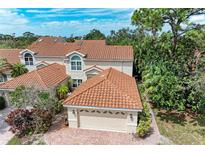 Aerial view of a house with a tile roof and two-car garage at 264 Woods Point Rd, Osprey, FL 34229