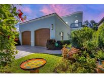Charming two-story home with a two-car garage, mature landscaping, and a decorative bird bath at 1884 Grove St, Sarasota, FL 34239