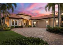Luxury home exterior with brick driveway and sunset view at 14619 Leopard Creek Pl, Lakewood Ranch, FL 34202